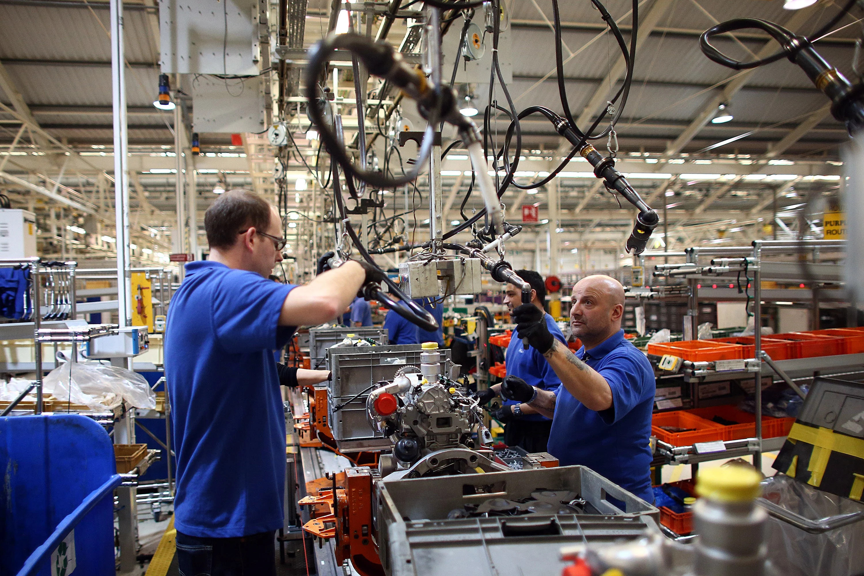 Employees work on an engine production line at a Ford factory on January 13, 2015 in Dagenham, England.